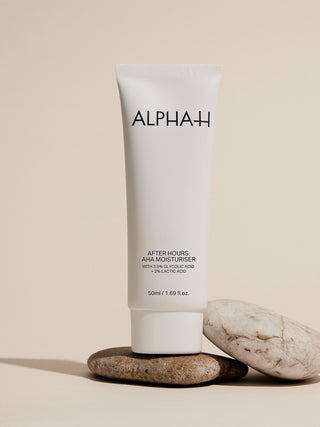 Alpha-H After Hours AHA Moisturiser op een stapel stenen