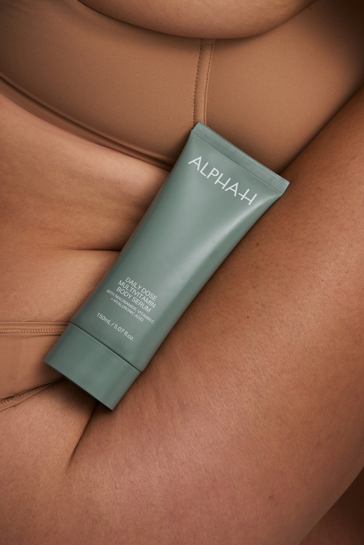 Alpha-H Daily Dose Multivitamin Body Serum tube tegen de arm
