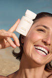 Alpha-H Liquid Gold Exfoliating Treatment model met flacon aan zee