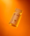 Alpha-H Liquid Gold + Vitamin C Exfoliating Treatment flacon in oranje licht
